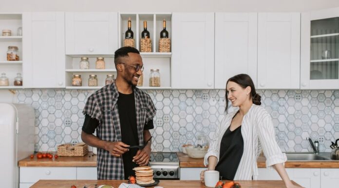 Couple discussing a refrigerator door closing routine in their kitchen