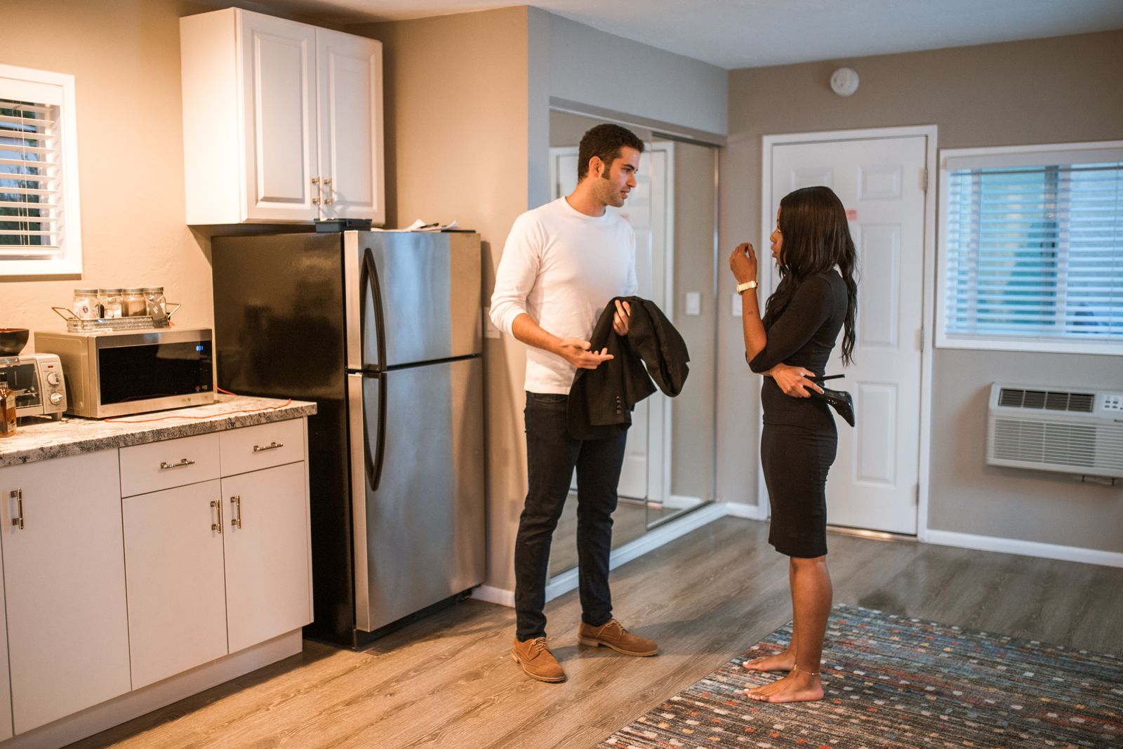 Couple discussing their shared water pitcher routine in the kitchen
