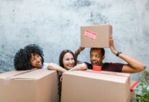 People organizing cardboard delivery boxes together in a shared home