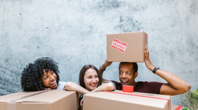 People organizing cardboard delivery boxes together in a shared home