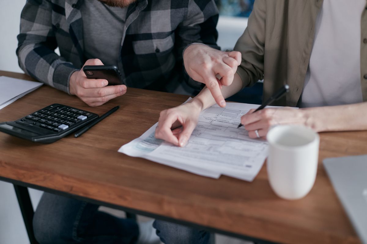 Couple reviewing household paperwork and deadlines together at a table