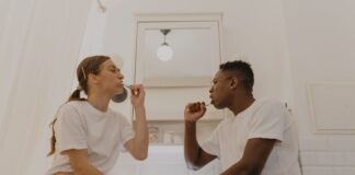 Couple sharing a bathroom while discussing their cleanup routine