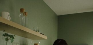 Couple making coffee together beside a coffee machine in their kitchen