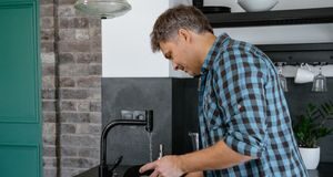 Couple talking while sharing dishwashing chores in their kitchen