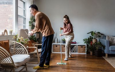 Couple cleaning their living room together and sharing household tasks