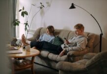 Couple using smartphones while sitting together in a shared living room