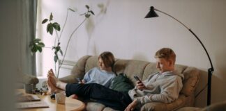 Couple using smartphones while sitting together in a shared living room