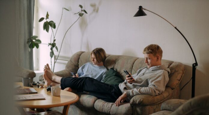 Couple using smartphones while sitting together in a shared living room