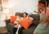 When Your Partner Never Empties the Vacuum Cleaner: How to Share the Whole Chore Couple sharing vacuum cleaner chores in their living room