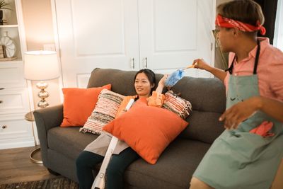 When Your Partner Never Empties the Vacuum Cleaner: How to Share the Whole Chore Couple sharing vacuum cleaner chores in their living room
