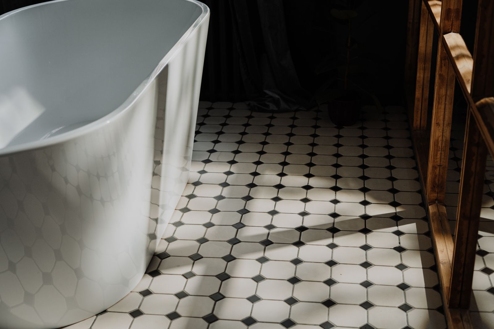 Dry tiled bathroom floor beside a bathtub
