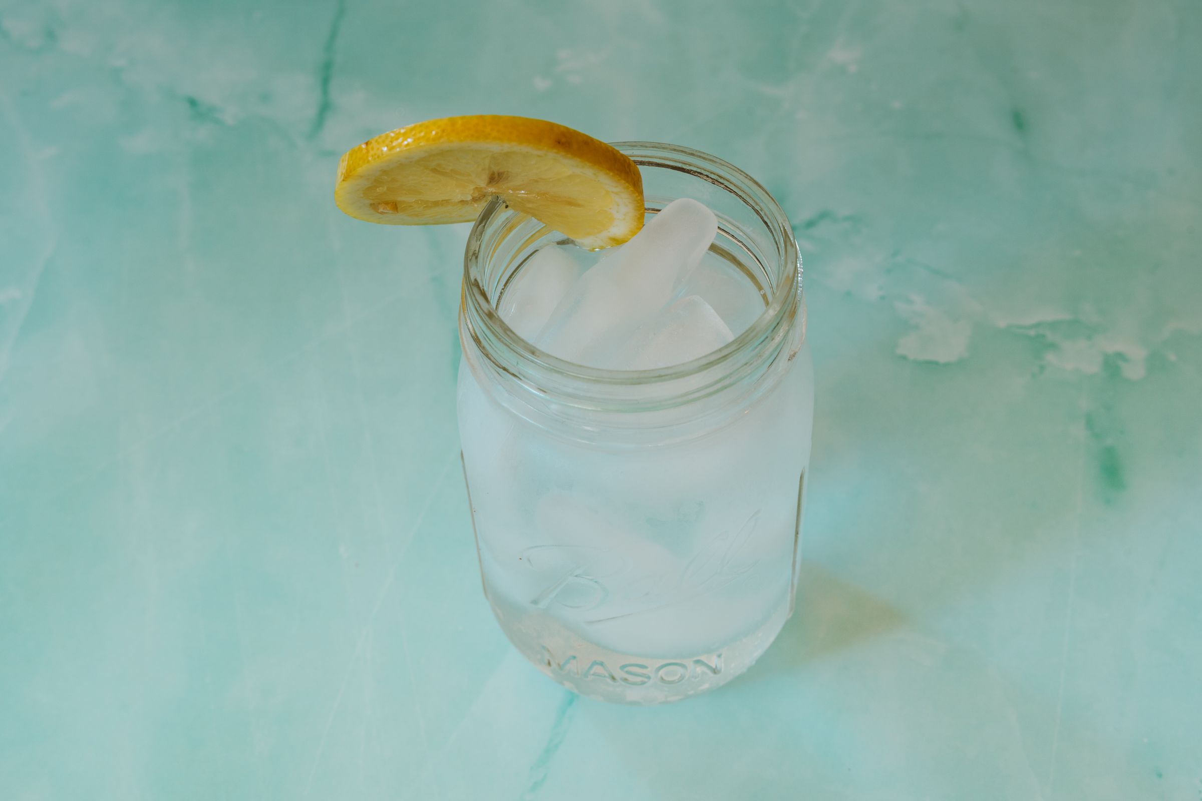 Glass of water with ice cubes and a slice of lemon