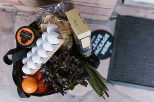 Reusable grocery bag with eggs fruit and vegetables ready to be checked against a shopping list