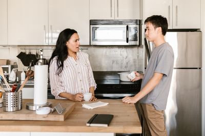 Couple discussing a kitchen restocking routine at home