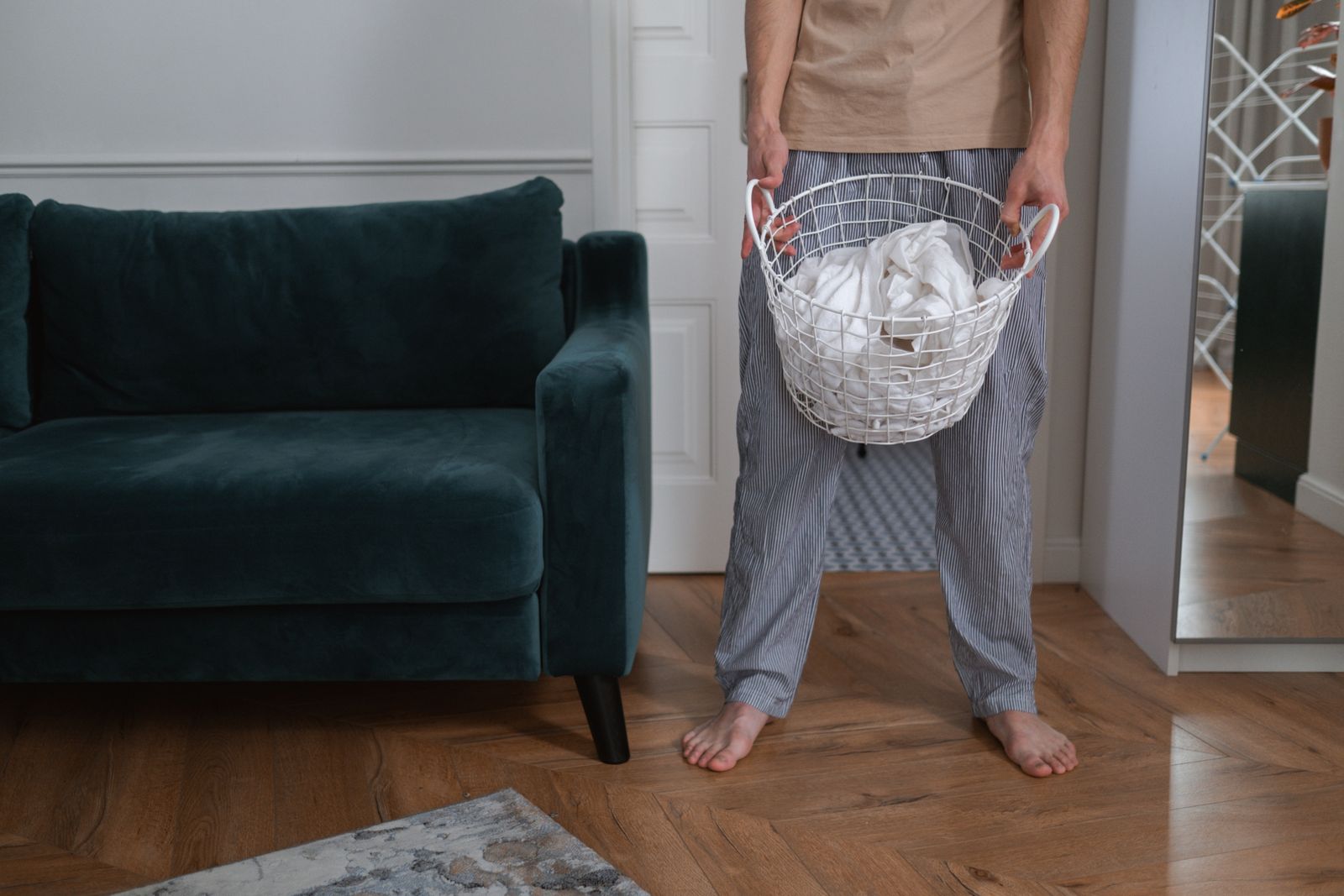Partner carrying a laundry basket through the living room