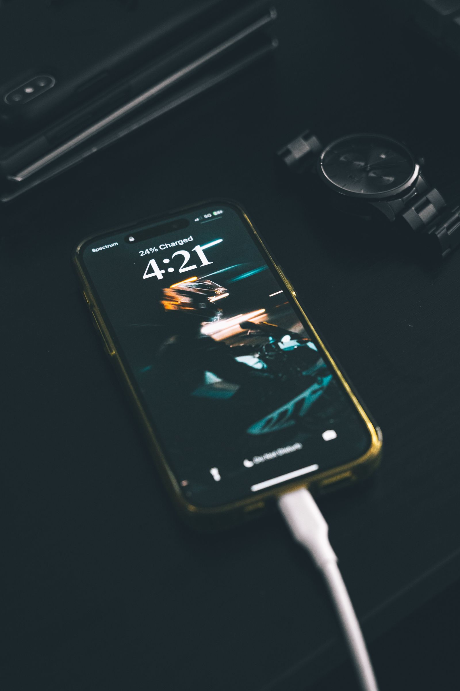 Smartphone connected to a charging cable on a table