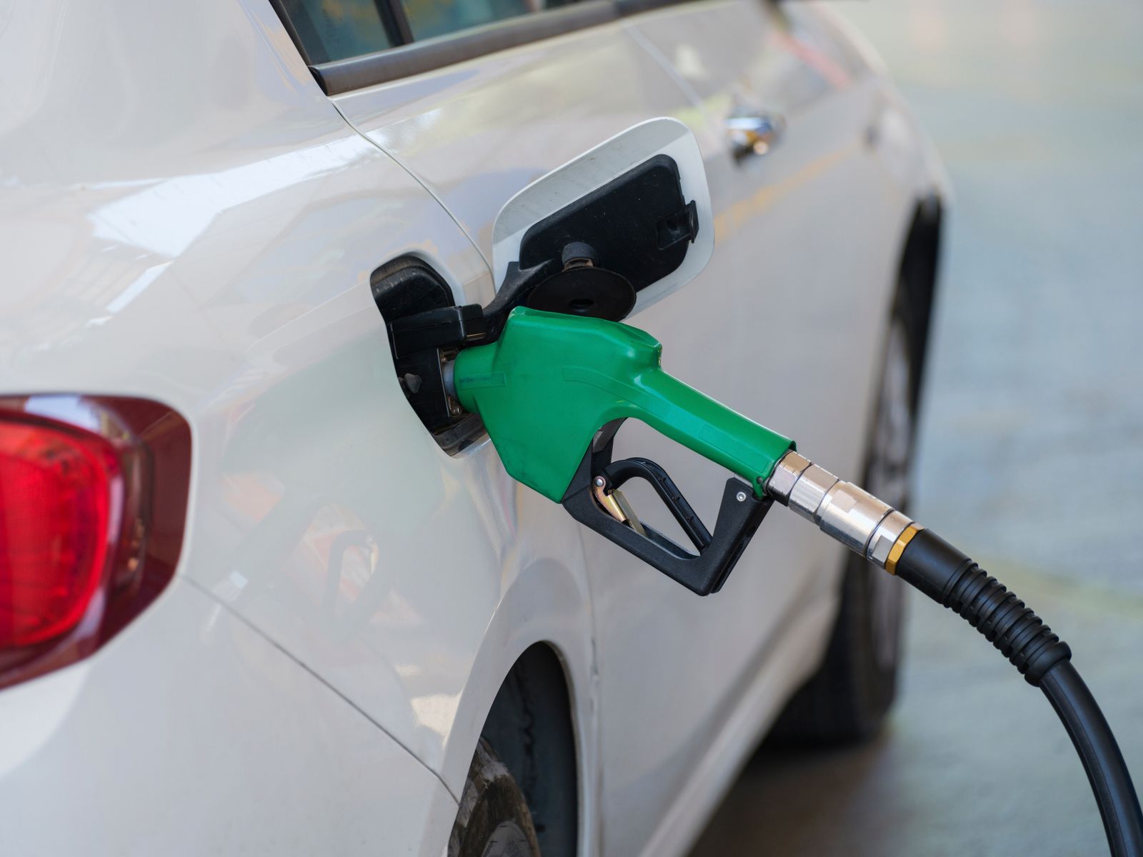 Fuel nozzle refilling a shared car at a gas station