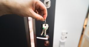 House keys held at a home doorway as part of a reliable daily routine