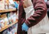 Shopper using a reusable grocery bag while selecting food in a supermarket