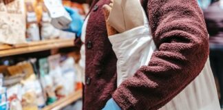 Shopper using a reusable grocery bag while selecting food in a supermarket
