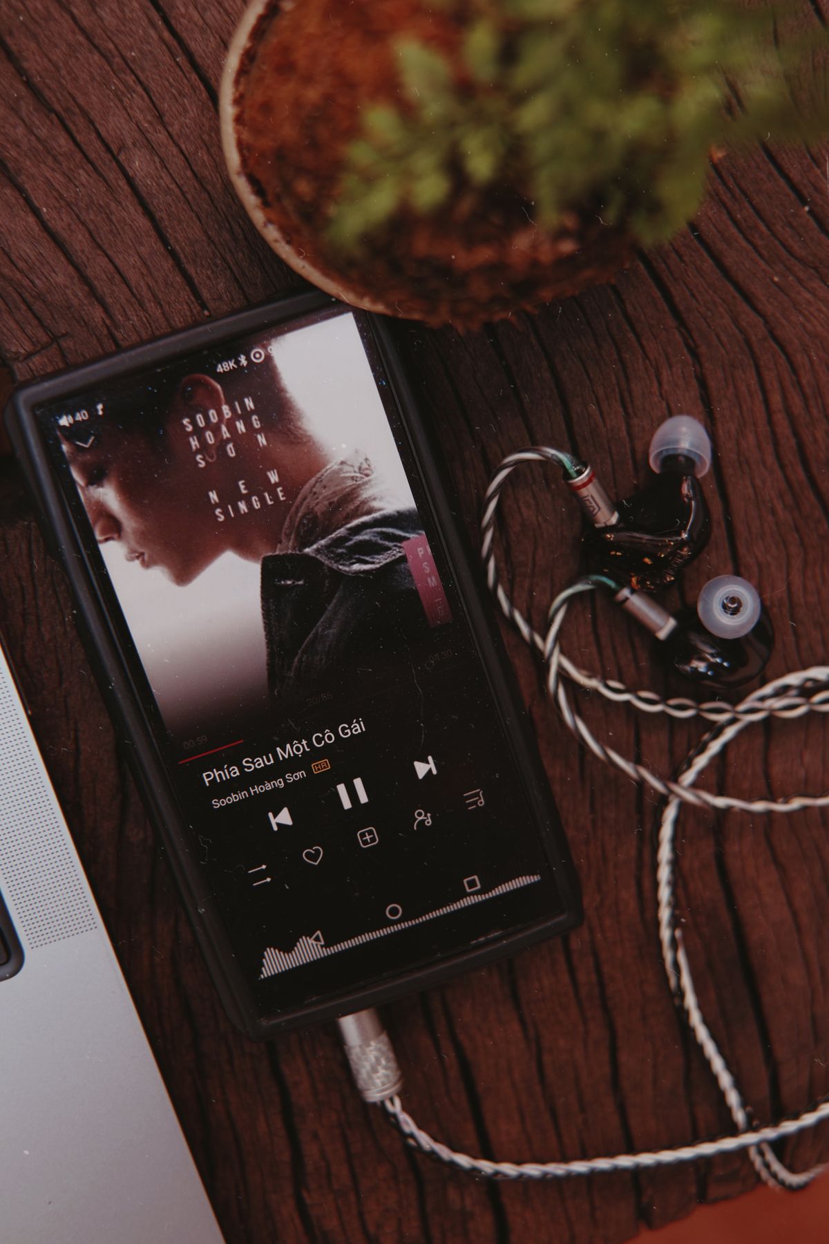 Smartphone and earphones on a wooden table ready for quiet personal listening