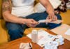 Person sorting household mail and papers while seated at home