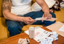 Person sorting household mail and papers while seated at home