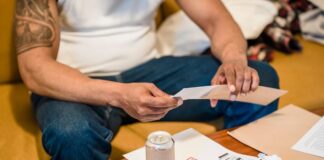 Person sorting household mail and papers while seated at home