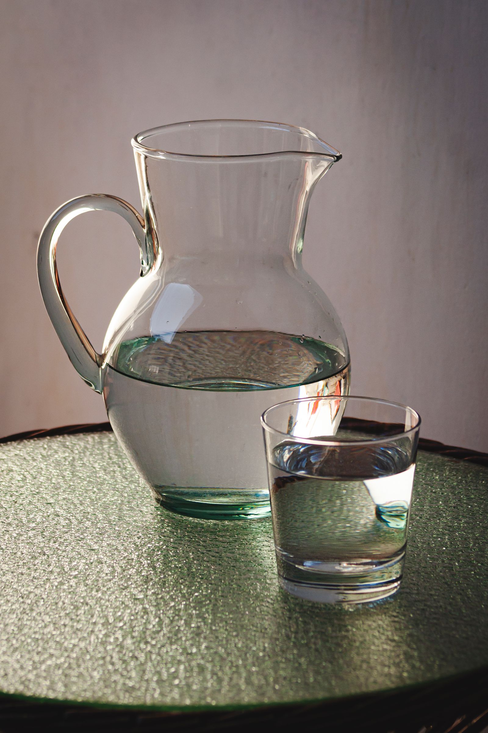 Water pitcher beside a drinking glass ready to be refilled
