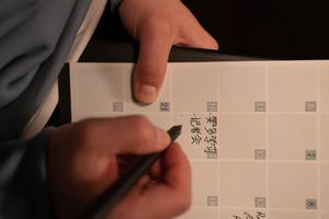 Person writing confirmed commitments in a shared paper calendar