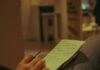 Bringing Notes to Couples Therapy: How to Prepare a Useful Session Agenda Person holding a pen and writing on paper indoors