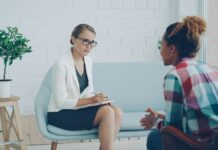 Two adults speaking during a consultation in a modern counseling office