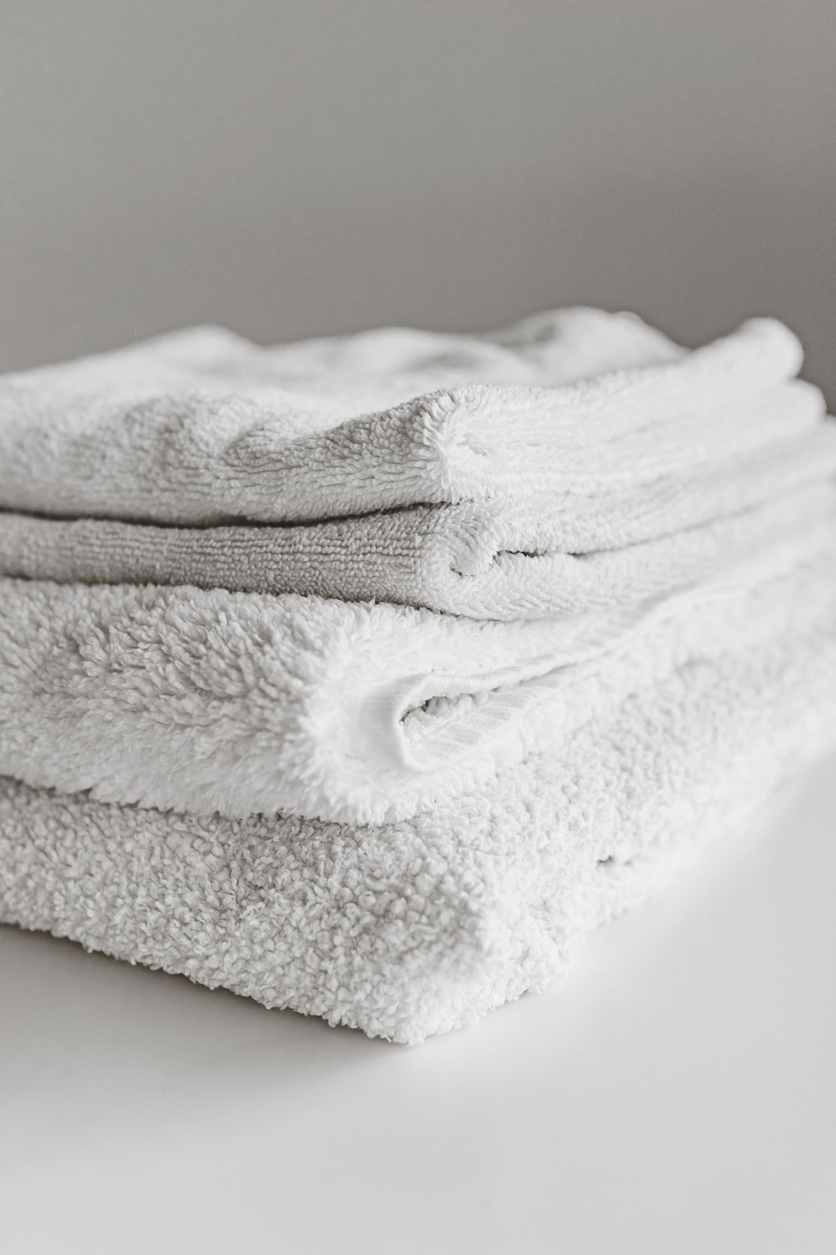 Neatly folded clean white towels stored together for household use