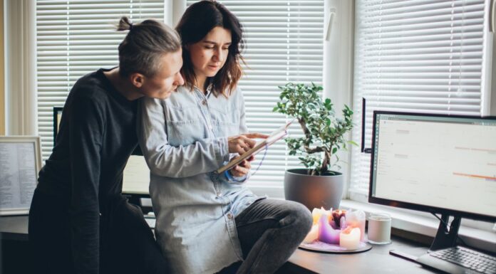 Two adults looking together at a device in a home office