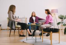 Three adults engaged in conversation in a modern living room