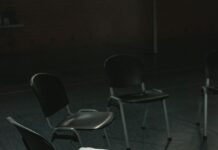 Empty chairs arranged in a circle in a sunlit indoor meeting space