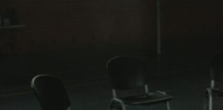 Empty chairs arranged in a circle in a sunlit indoor meeting space