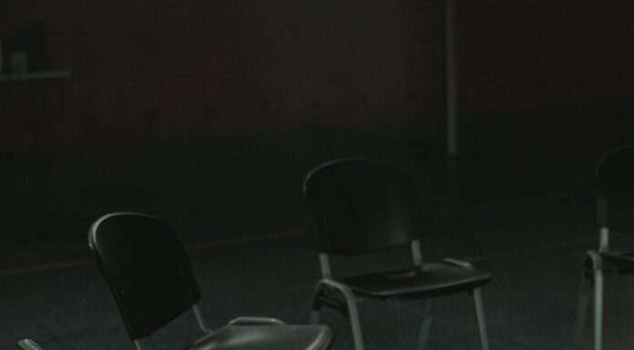 Empty chairs arranged in a circle in a sunlit indoor meeting space