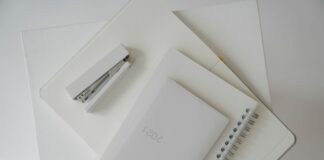 Notebook, diary, and white stapler arranged on an open planner
