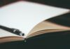 Close-up of a pen resting on an open notebook