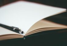 Close-up of a pen resting on an open notebook
