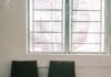 Two empty chairs beside a window in a waiting room
