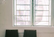 Two empty chairs beside a window in a waiting room