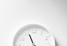 Minimalist white wall clock with dark hands and hour markers
