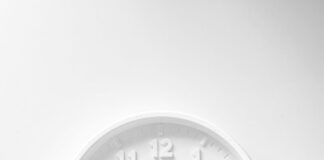 Minimalist white wall clock with dark hands and hour markers