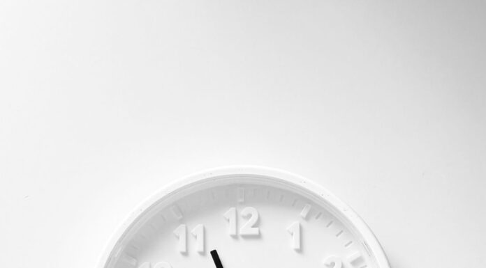 Minimalist white wall clock with dark hands and hour markers