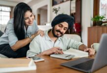 Couple at home reviewing paperwork with a laptop and calculator