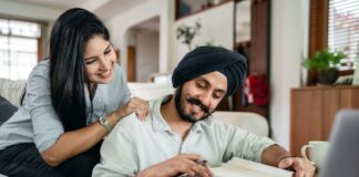 Couple at home reviewing paperwork with a laptop and calculator