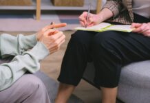 Couples Therapy With a Trainee: What to Ask About Supervision Therapist and client seated in armchairs with a notebook during a consultation