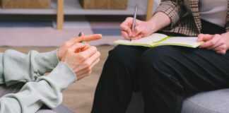 Therapist and client seated in armchairs with a notebook during a consultation